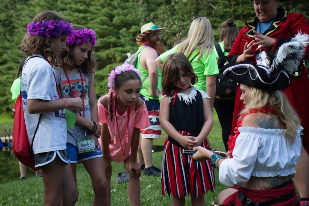 Trinity, a pirate entertainer at Black Tide Buccaneers, captivates an audience of young girls at Camp Quality as she shows them how a flintlock works.